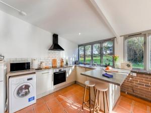 eine Küche mit Waschmaschine und Trockner in der Unterkunft The Owl Barn - Uk48736 in Gaerwen