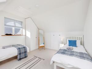 ein weißes Schlafzimmer mit zwei Betten und einem Spiegel in der Unterkunft The Owl Barn - Uk48736 in Gaerwen