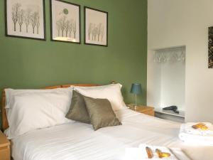 a bedroom with a white bed with three pictures on the wall at Belle View - 26645 in Bowness-on-Windermere