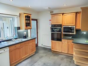 a kitchen with wooden cabinets and a sink at Crossfeld in Keswick