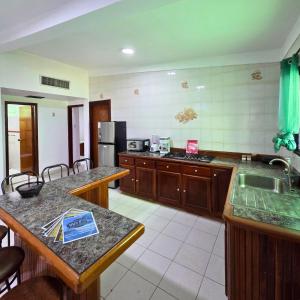 eine Küche mit Holzschränken und einer Arbeitsplatte in der Unterkunft Tucacas, Frente al Mar, Vista a la Piscina y Playa Privada in Boca de Aroa