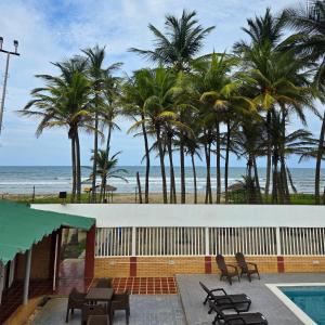 ein Resort mit Pool, Palmen und Meer in der Unterkunft Tucacas, Frente al Mar, Vista a la Piscina y Playa Privada in Boca de Aroa