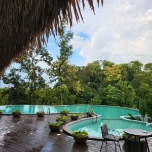 a swimming pool with chairs and tables on a deck at Red River Retreat in Hatikhuli