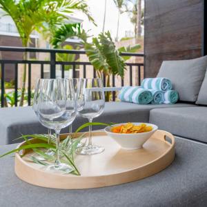 ein Tablett mit zwei Weingläsern und einer Schüssel Cracker in der Unterkunft Summer Breeze in Blue Bay