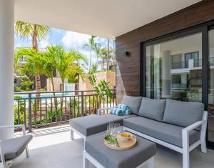 ein Wohnzimmer mit Couch und Balkon in der Unterkunft Summer Breeze in Blue Bay