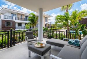 eine Terrasse mit einem Sofa und Stühlen auf dem Balkon in der Unterkunft Summer Breeze in Blue Bay
