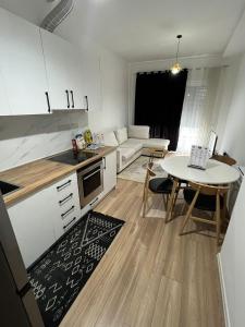 ティラナにあるCentaurus Apartmentsのキッチンとテーブルとソファのあるリビングルーム +15枚の写真
