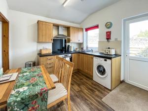 Una cocina con una mesa y un comedor. en Kilquhanity Cottage, en Castle Douglas