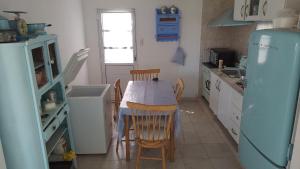 a kitchen with a table and chairs and a refrigerator at Complejo La Emilce in Olavarría