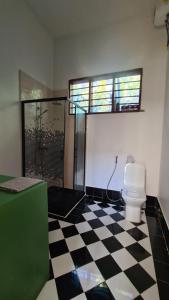 a bathroom with a toilet and a black and white checkered floor at Solaya Residence - Boutique Beach-House in Kizimkazi with Garden & Parking  +31 photos