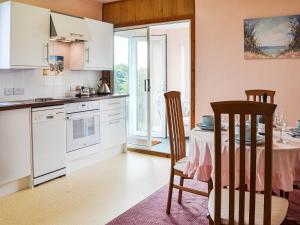 a kitchen with a table and chairs and a dining room at Sunny Bank - Uk34711 in Reighton +13 photos