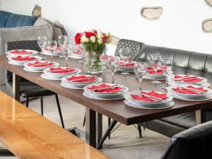 a table with red and white plates and wine glasses at Fieldgate Barn-Uk47179 in Bampton