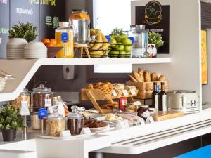 a bakery counter with bread and other food items at Ibis Budget Madrid Vallecas in Madrid