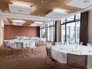 a conference room with white tables and chairs and windows at Mercure Amiens Cathédrale in Amiens