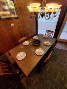 a dining room table with plates and wine glasses on it at Gatlinburg Mountain Cabin with Modern Comforts in Chalet Village