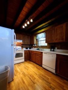 a kitchen with wooden floors and a white refrigerator at Gatlinburg Mountain Cabin with Modern Comforts in Chalet Village +12 photos