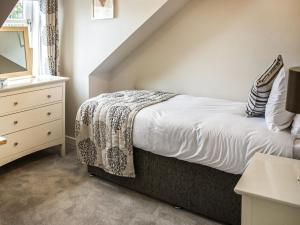 a bedroom with a bed and a dresser with a mirror at The Loans Inn Cottage in Loans