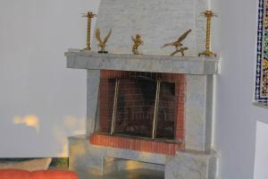 a brick fireplace with a bird figurines on top of it at Luxury Villa 4-Bedroom Estate with Panoramic Tanger Bay Sea View, Private Pool, Garden in Noûnouech