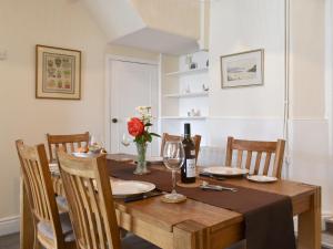 ein Esszimmer mit einem Holztisch und einer Flasche Wein in der Unterkunft Steps End in Brixham