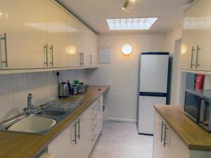 eine Küche mit Spüle und Kühlschrank in der Unterkunft Steps End in Brixham