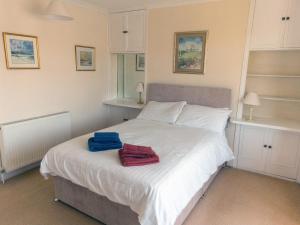 ein Schlafzimmer mit einem weißen Bett mit zwei Handtüchern darauf in der Unterkunft Steps End in Brixham + 13 Fotos