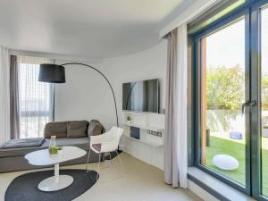 a living room with a couch and a table at Novotel Suites Paris Issy Les Moulineaux in Issy-les-Moulineaux