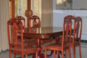 a dining room table with four chairs around it at Luxury Villa 4-Bedroom Estate with Panoramic Tanger Bay Sea View, Private Pool, Garden in Noûnouech