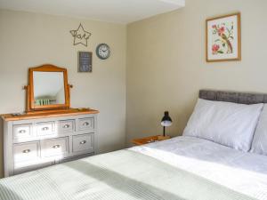 a bedroom with a bed and a mirror and a dresser at Heather Cottage in Bishop Auckland +5 photos