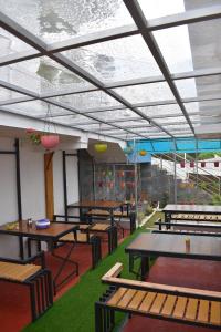 a room with tables and benches in a restaurant at diamond hill view cottage in Ooty