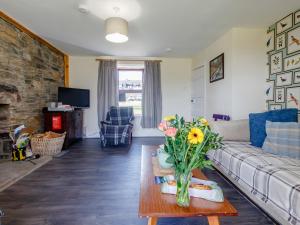Una sala de estar con un sofá y una mesa con flores. en 19 South Street, en Grantown-on-Spey 16 fotos más