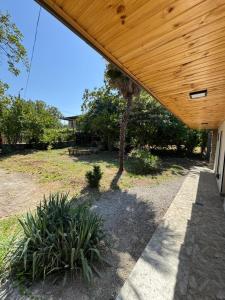 une terrasse couverte d'une maison avec un toit en bois dans l'établissement Green Garden, à Tsinandali