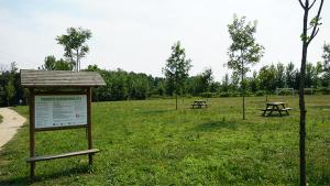 a park with picnic tables and a sign in the grass at Quatro Ponto Cinco in Caldelas