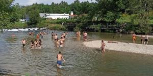 a group of people in the water at a beach at Quatro Ponto Cinco in Caldelas