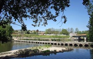 a bridge over a river with a bridge in the background at Quatro Ponto Cinco in Caldelas