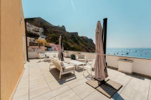 a balcony with an umbrella and a view of the ocean at Stella di Mare in Procida
