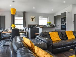 a living room with a leather couch and a kitchen at The Barbon - Uk47033 in Kirkby Lonsdale