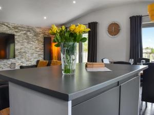 a vase of yellow flowers on a kitchen island at The Barbon - Uk47033 in Kirkby Lonsdale +14 photos