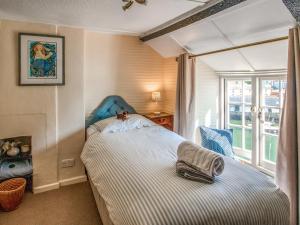 a bedroom with a bed with a teddy bear sitting on it at Charlie Wilcox Cottage in Polperro +14 photos