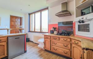 a large kitchen with wooden cabinets and a sink at Havre De Paix À La Campagne in Lebiez