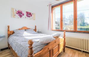 a bedroom with a wooden bed and a window at Havre De Paix À La Campagne in Lebiez