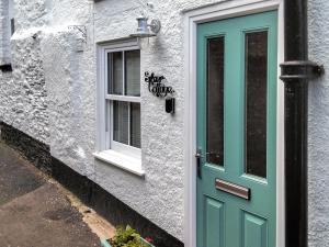 a building with a green door and a window at Silver Cottage in Dartmouth +4 photos
