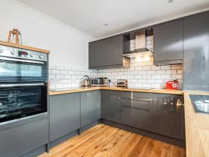 a kitchen with stainless steel appliances and wooden floors at Flat 1 in Inverness