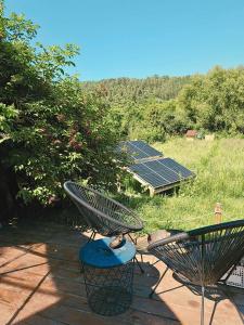 two chairs sitting on a patio with solar panels at Pacha Garden - The Dome in Miceşti +19 photos