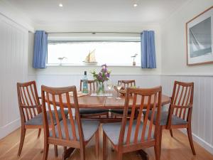 mesa de comedor con 4 sillas y ventana en Devon Court 2, en Salcombe