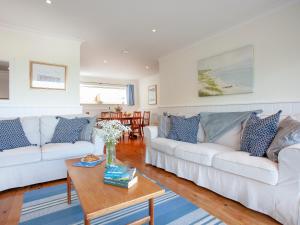 Una sala de estar con dos sofás blancos y una mesa. en Devon Court 2, en Salcombe