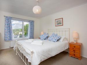 Un dormitorio con una cama blanca con una ventana. en Devon Court 2, en Salcombe 9 fotos más