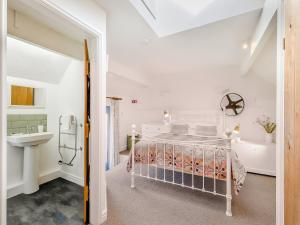 Un dormitorio con una cama, un lavabo y una bañera. en The Granary - Uk48740, en Gaerwen