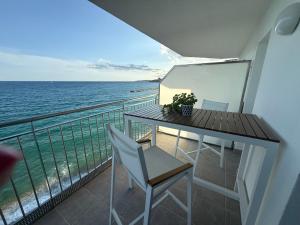 un balcon avec une table et des chaises et l'océan dans l'établissement Pis a primera línia a Calonge, à Sant Antoni de Calonge