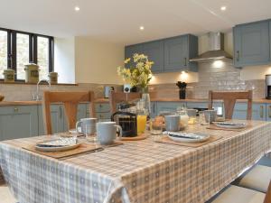 a kitchen with a table with a table cloth on it at Bucknole Farm - The Old Shippon in Northleigh +19 photos