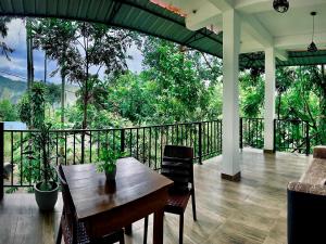 a porch with a table and chairs on a balcony at Ella Forest Eco View in Ella